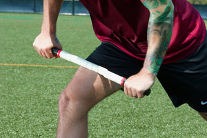 picture showing a male athlete massage leg muscle using a handheld plastic stick